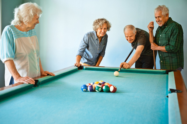 A group of elderly people playing pool.